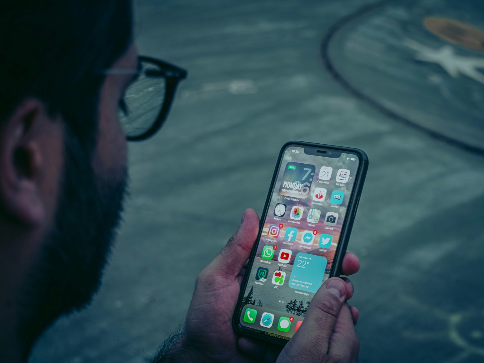 Homme qui fait défiler le fil d'actualité de son téléphone, là où s'affichent les publicités Facebook